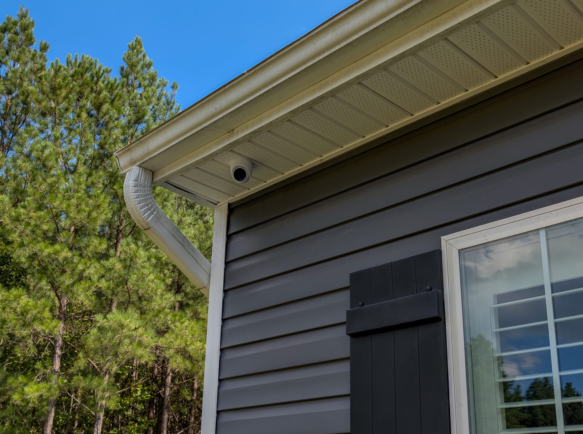 UniFi Protect turret camera soffit-mounted at the roofline of a residence