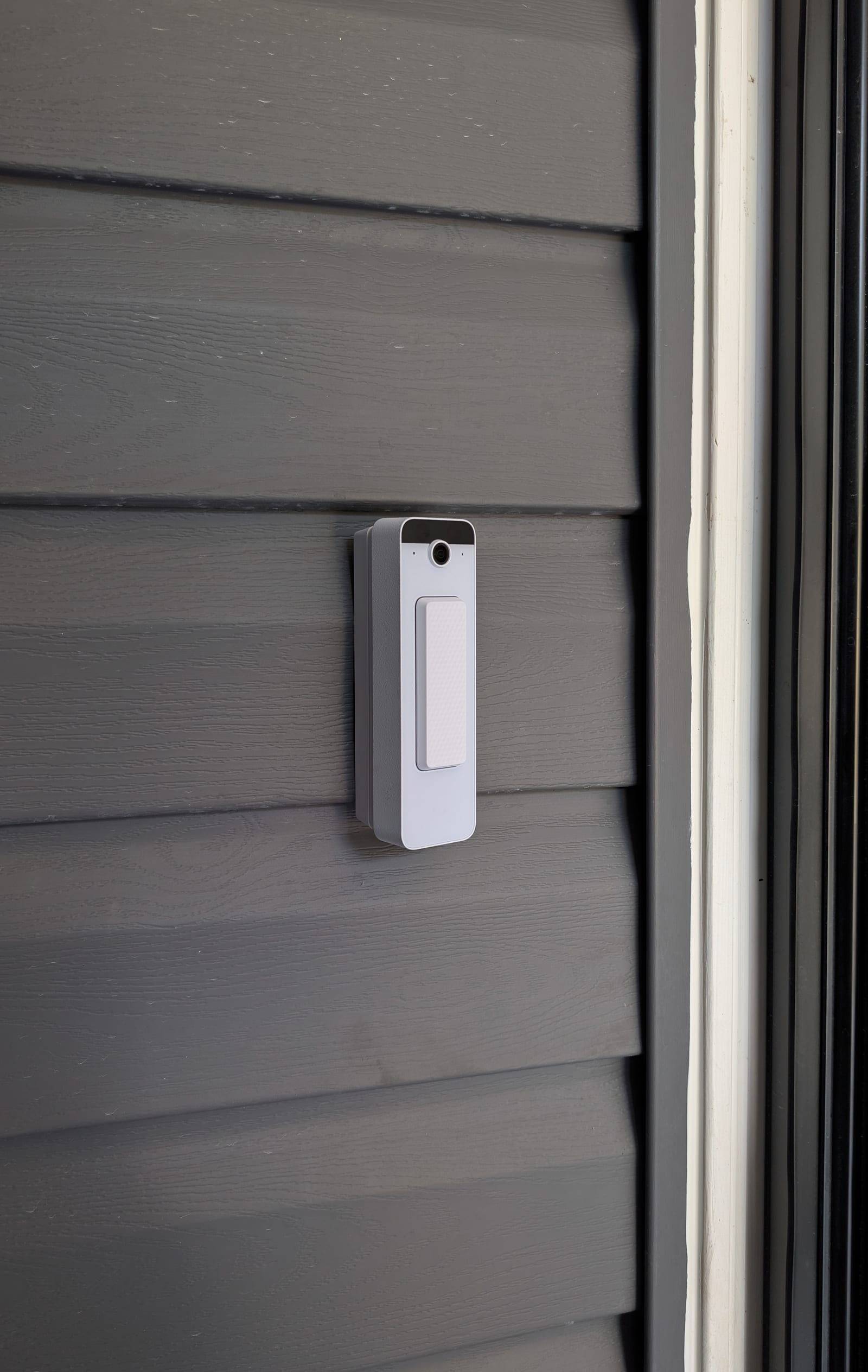 UniFi Protect doorbell station installed on siding beside the entry door