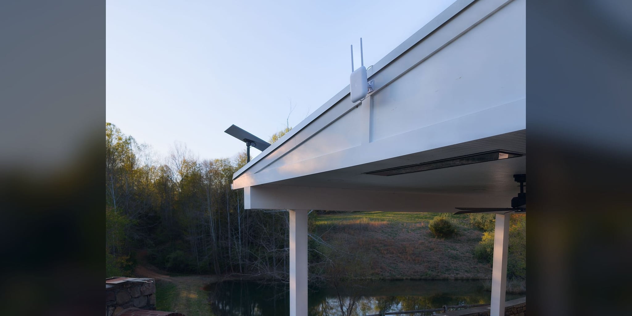 UniFi U7 Pro Outdoor access point and Starlink dish on the pavilion fascia overlooking the estate pond — Castleton, Virginia