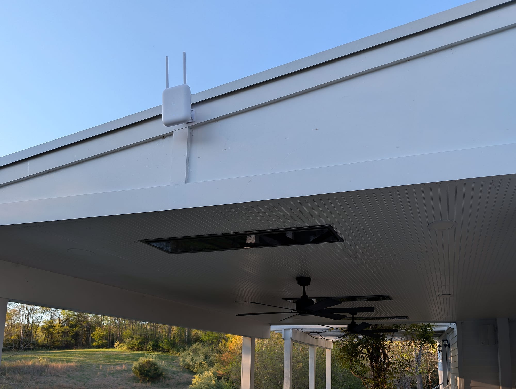 Outdoor access point on the pavilion fascia, above a ceiling fan and outdoor seating