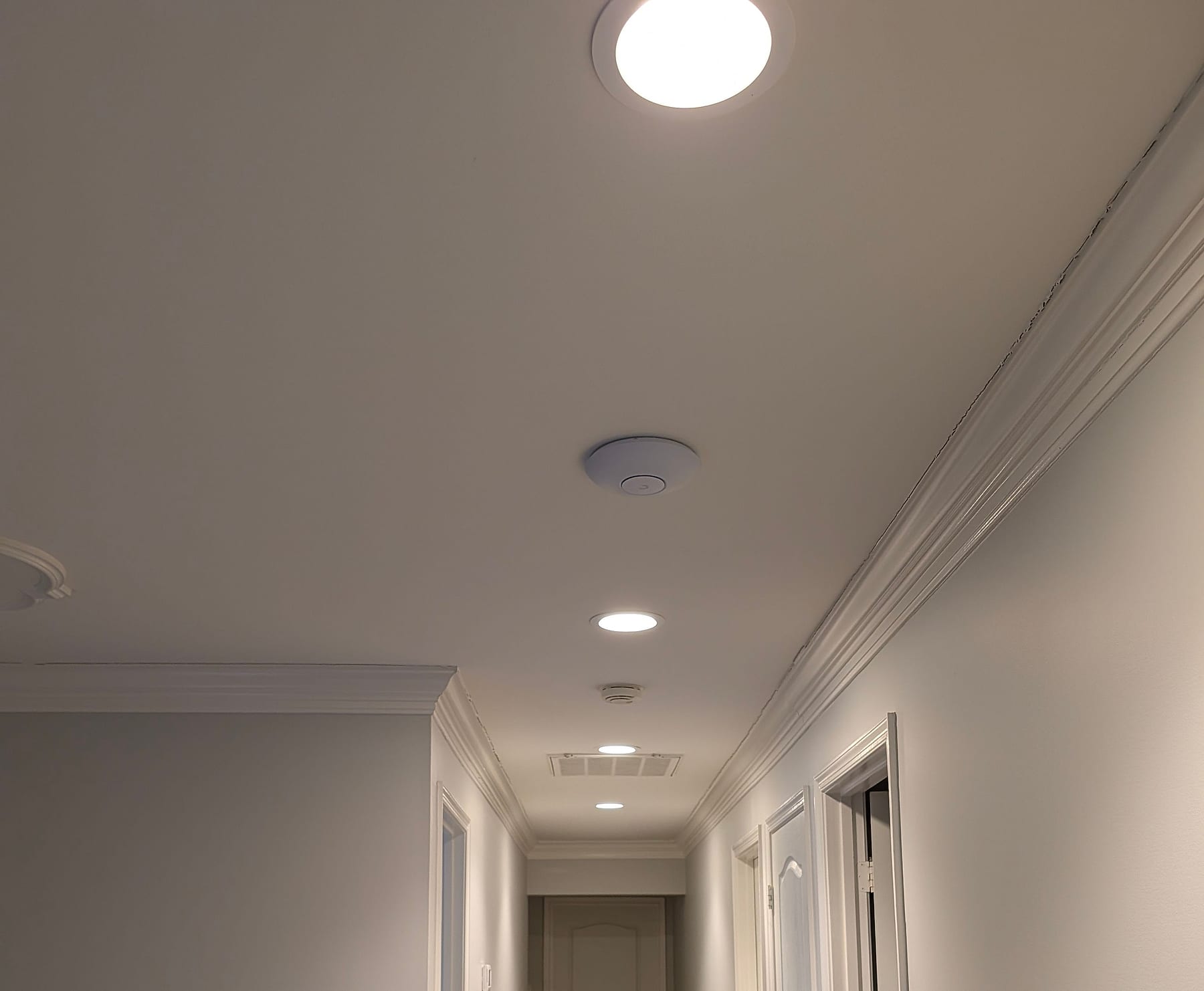 Access point on the second-floor hallway ceiling, photographed during installation