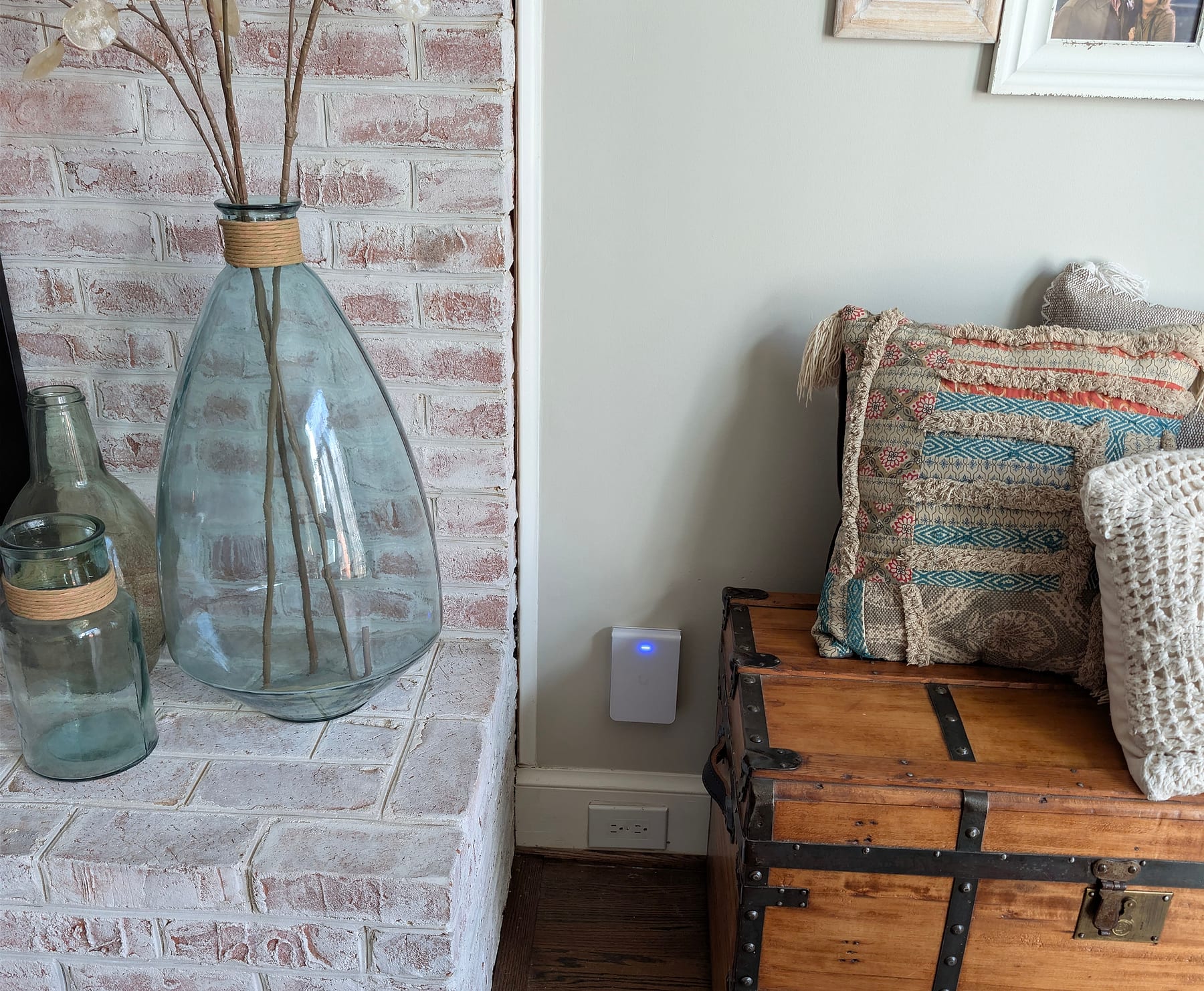 Access point on the living-room wall beside a whitewashed brick fireplace in Great Falls, Virginia