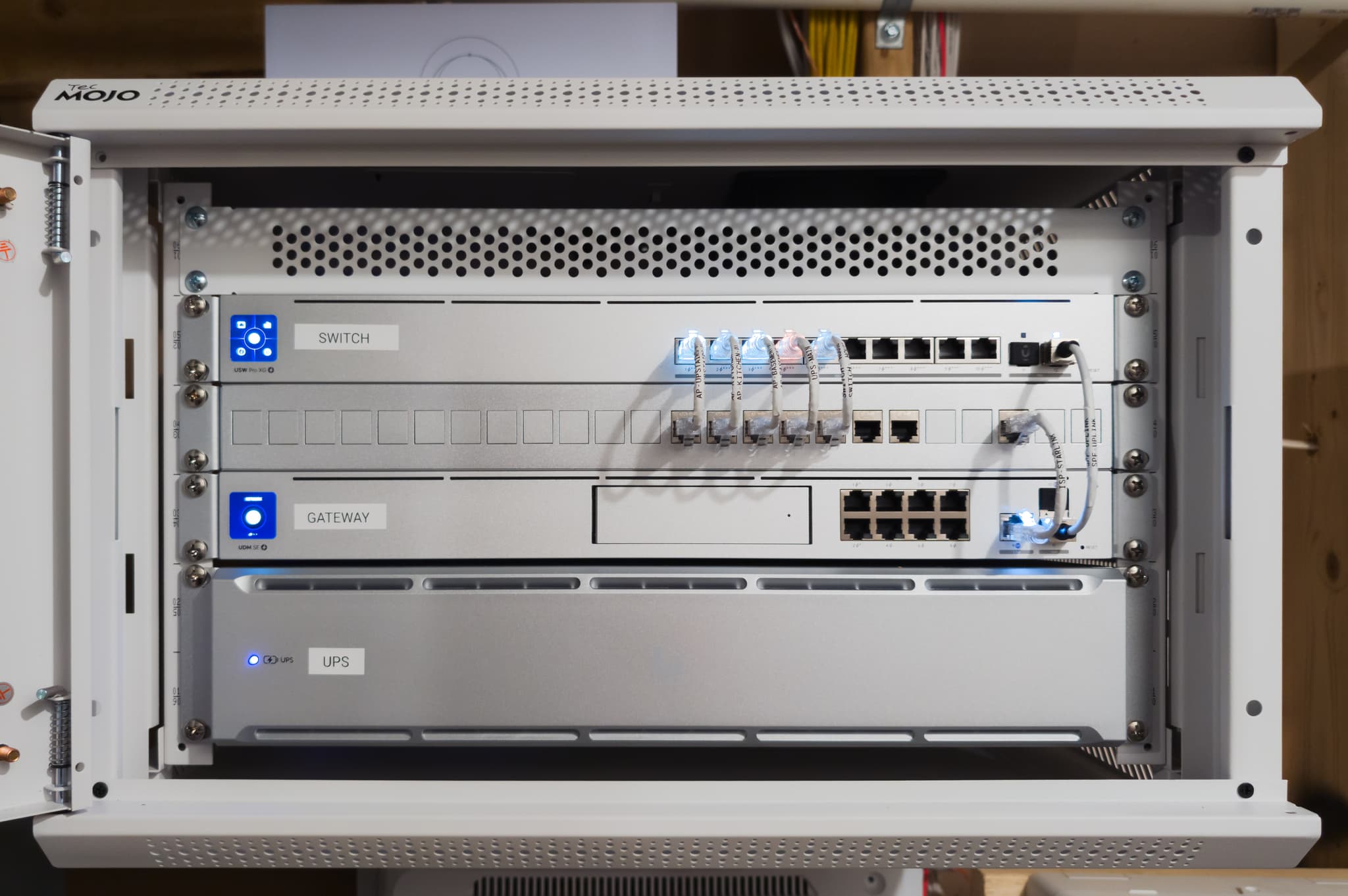 Rack-mounted UDM SE, USW Pro XG 10 PoE switch, and UPS 2U — all LEDs active, every device named and monitored