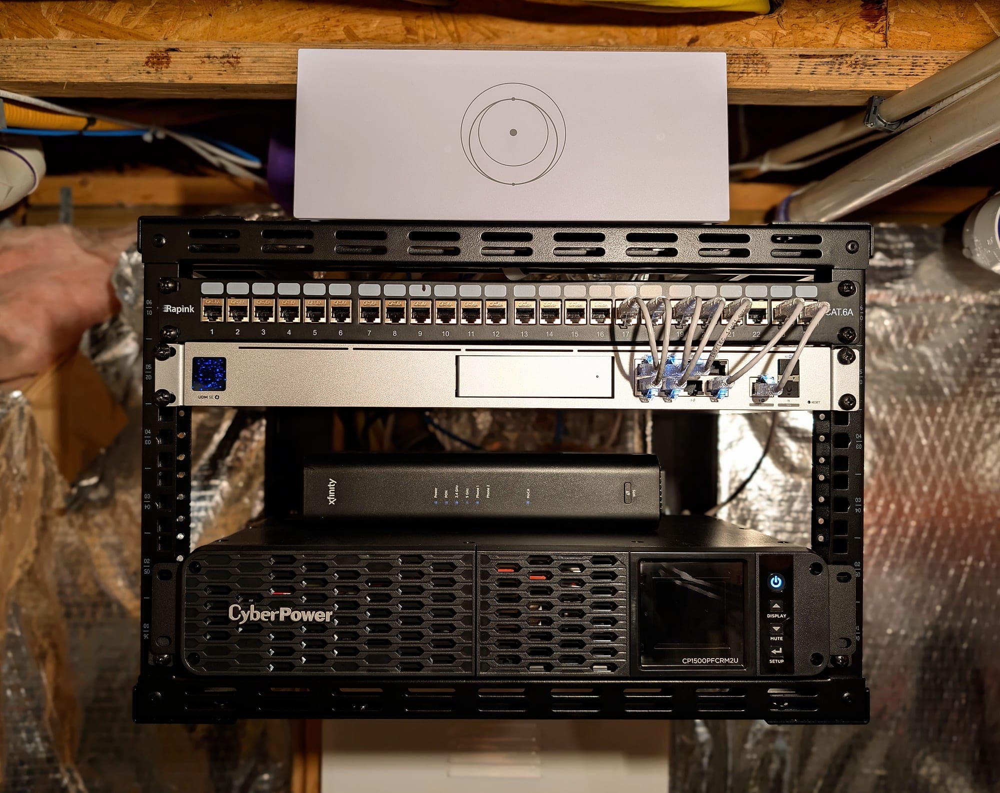 Rack detail — patch leads from the switch, UPS at the base