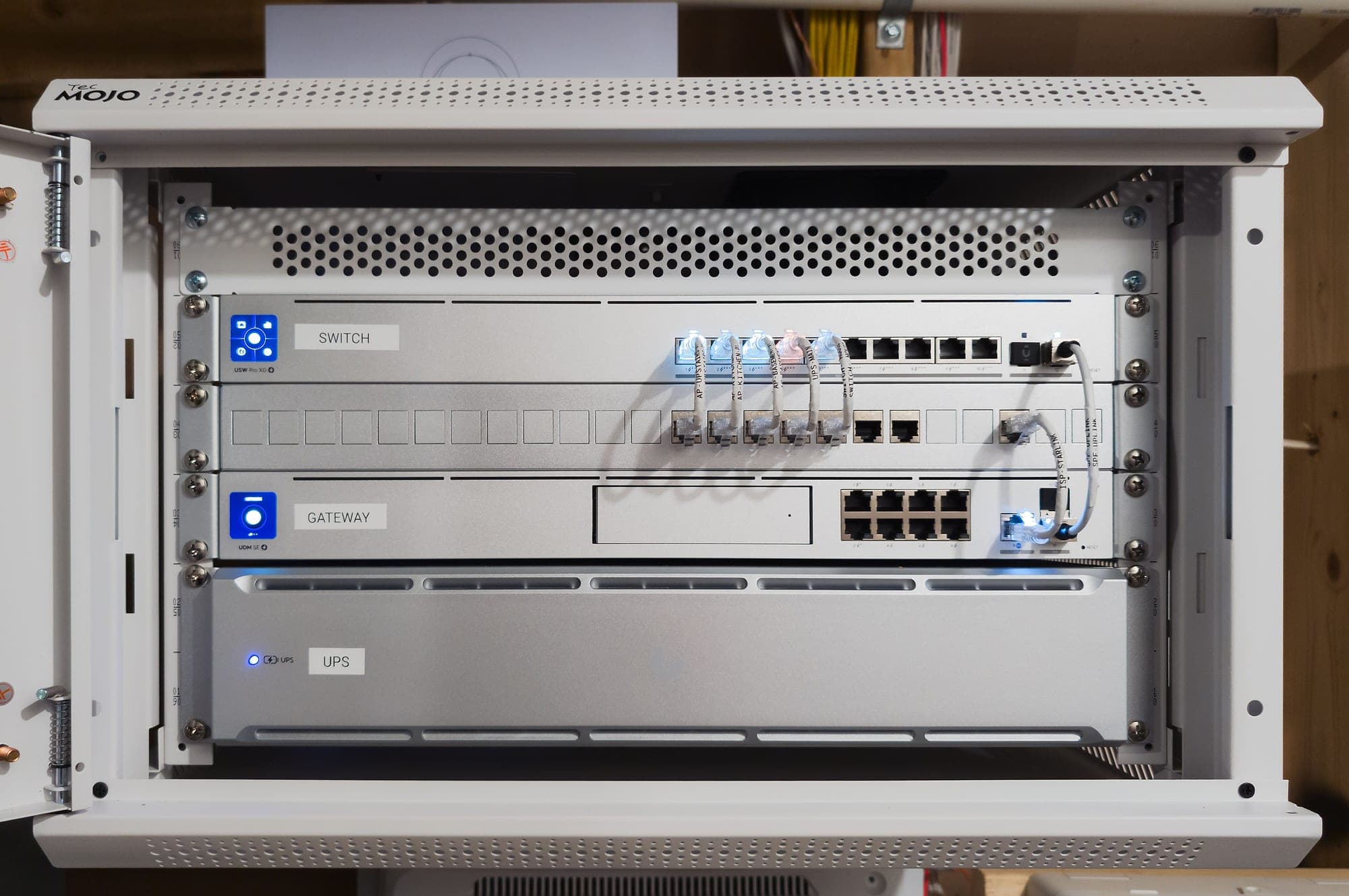 Wall-mount rack cabinet with the glass door closed and status LEDs visible