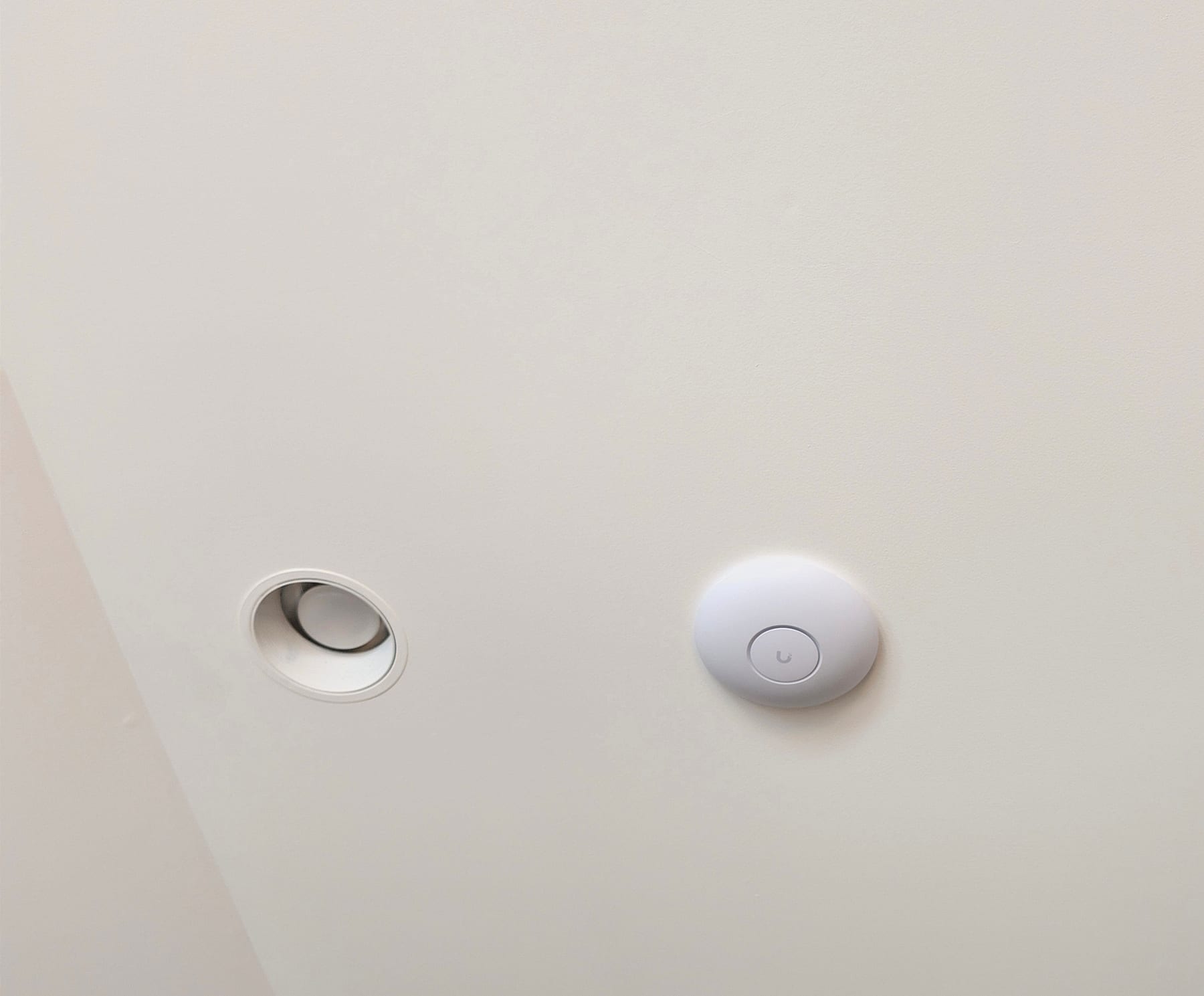 Ceiling-mounted Wi-Fi access point set flush among recessed lighting in a Potomac, Maryland residence