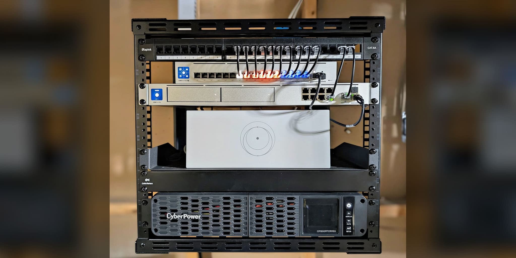 Commissioned open-frame network rack in Potomac, MD — UniFi gateway, PoE switch, labeled patch panel, Starlink router, and CyberPower pure sine-wave UPS